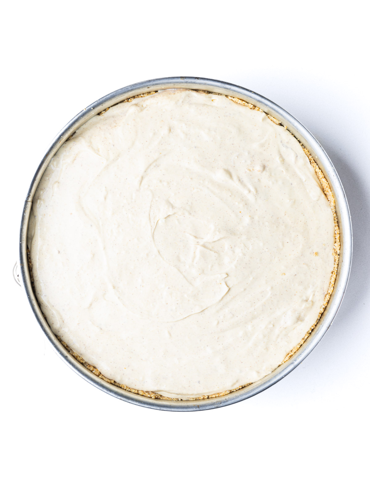 An unbaked pumpkin pie cheesecake in a springform pan.
