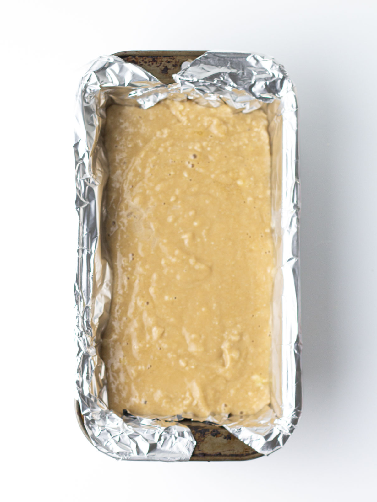 Chai bread batter in the foil lined metal loaf pan.