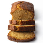 An angled view of a loaf of chai bread with three slices cut and leaning away from the rest of the loaf.