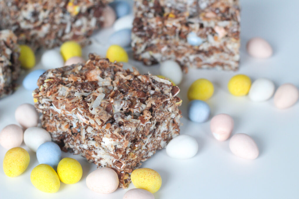 Chocolate coconut cereal bars surrounded by cadbury mini eggs.