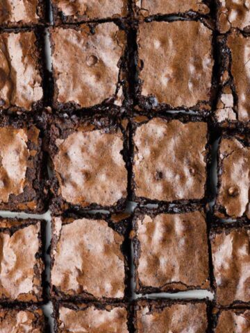 A close up of a batch of brownies cut into squares showing slight separation between some of the squares.