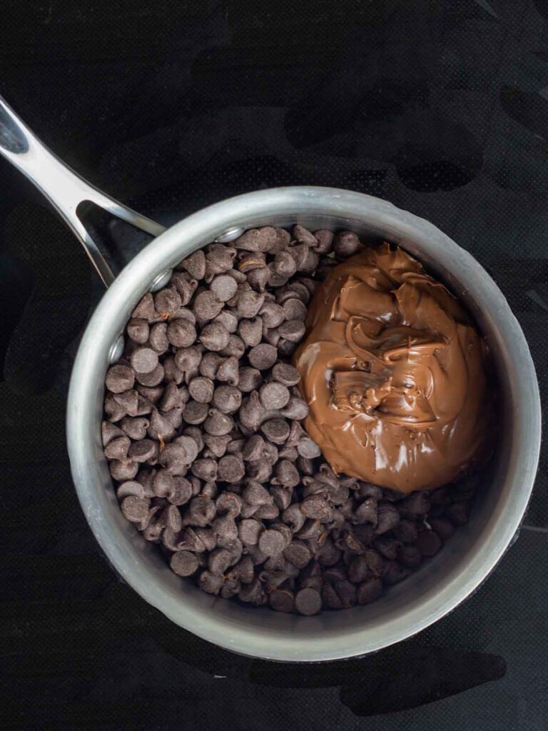 A saucepan with chocolate chips and Nutella.
