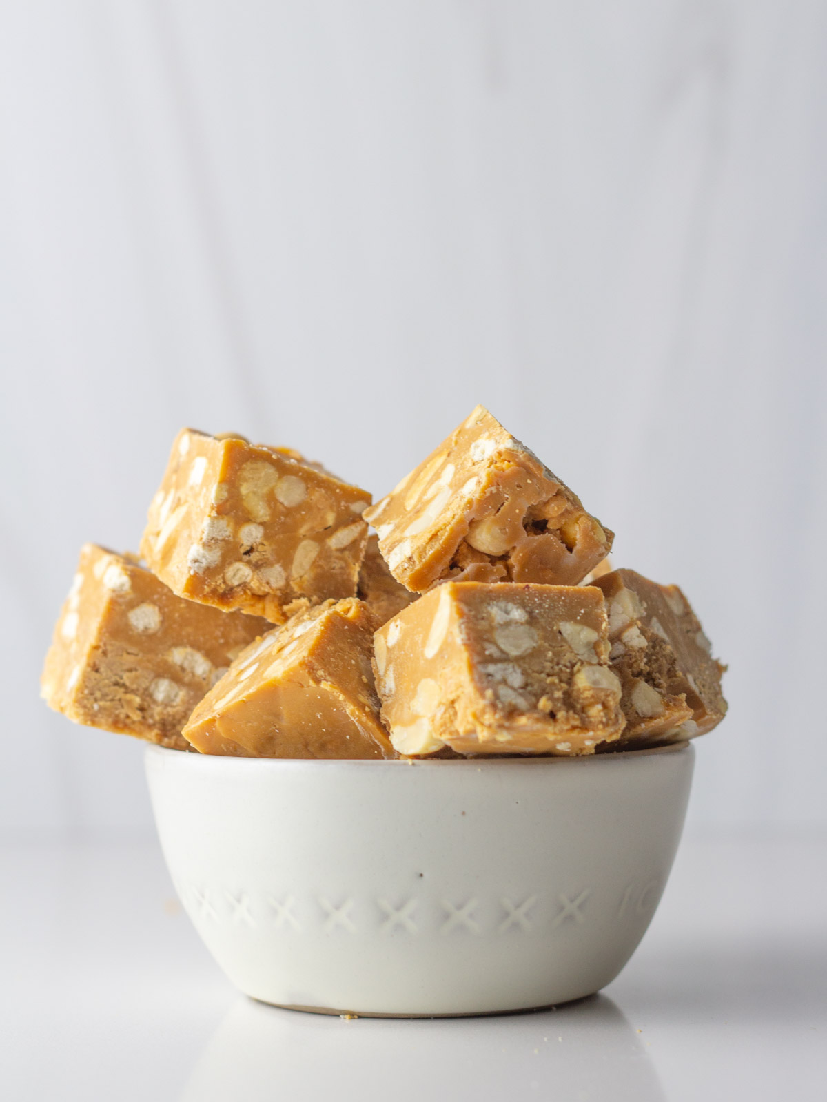 A white bowl holding cubes of salted caramel fudge.