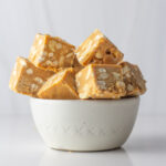 A white bowl holding cubes of salted caramel fudge.