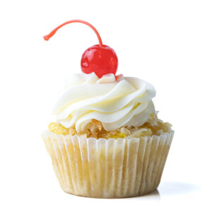 A single piña colada cupcake topped with buttercream frosting and a maraschino cherry on a white surface.