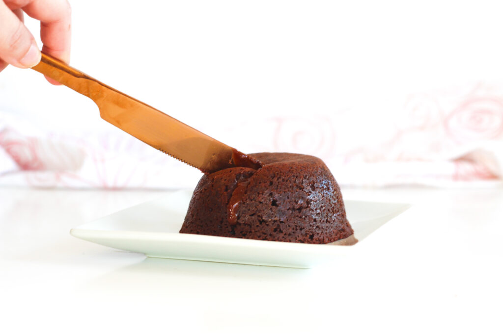a knife cutting a single-serving luxurious red wine molten chocolate lava cake