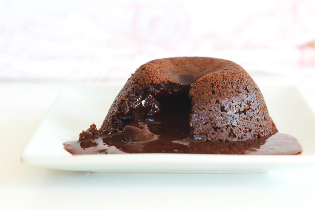 individual simple homemade red wine flourless chocolate cake with molten lava center oozing out.