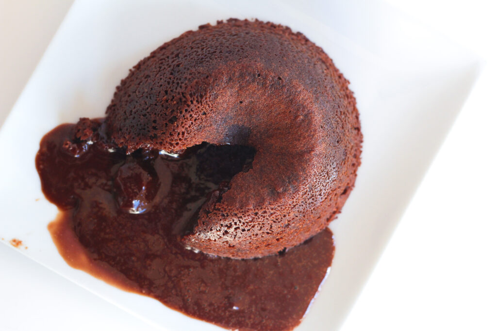 a red wine chocolate lava cake oozing out the liquid chocolate lava center.
