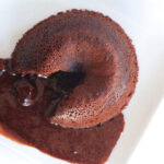 a red wine chocolate lava cake oozing out the liquid chocolate lava center.