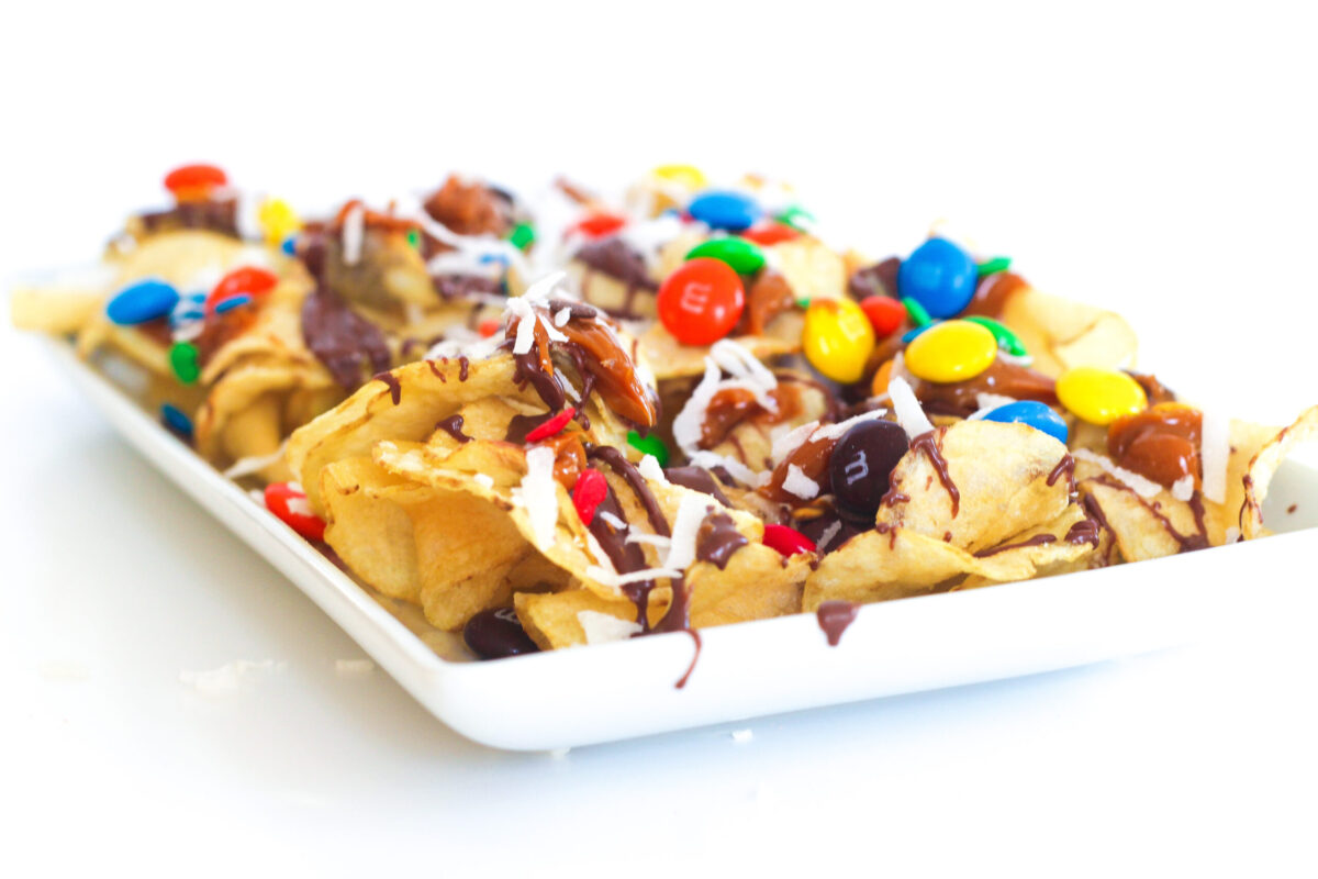 Corner of a white plate loaded with quick and easy dessert nachos.