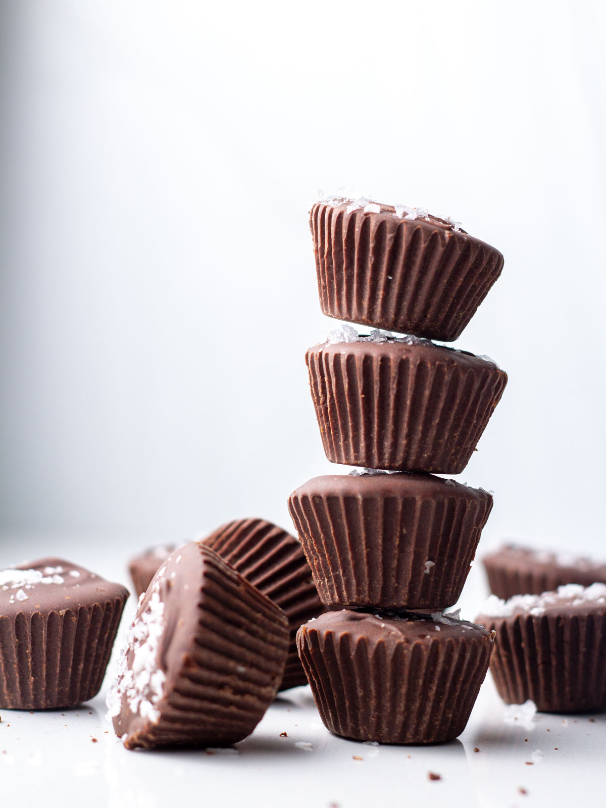A side view of a stack of four Nutella cups surrounded by more Nutella cups.