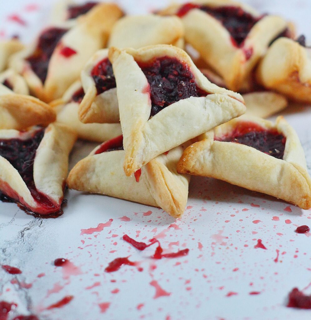 sangria hamentaschen sangria hamentashen on a white marble surface with some splatters of filling on the marble