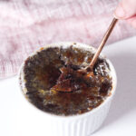 a spoon breaking through the crystalized topping of red wine chocolate creme brulee.