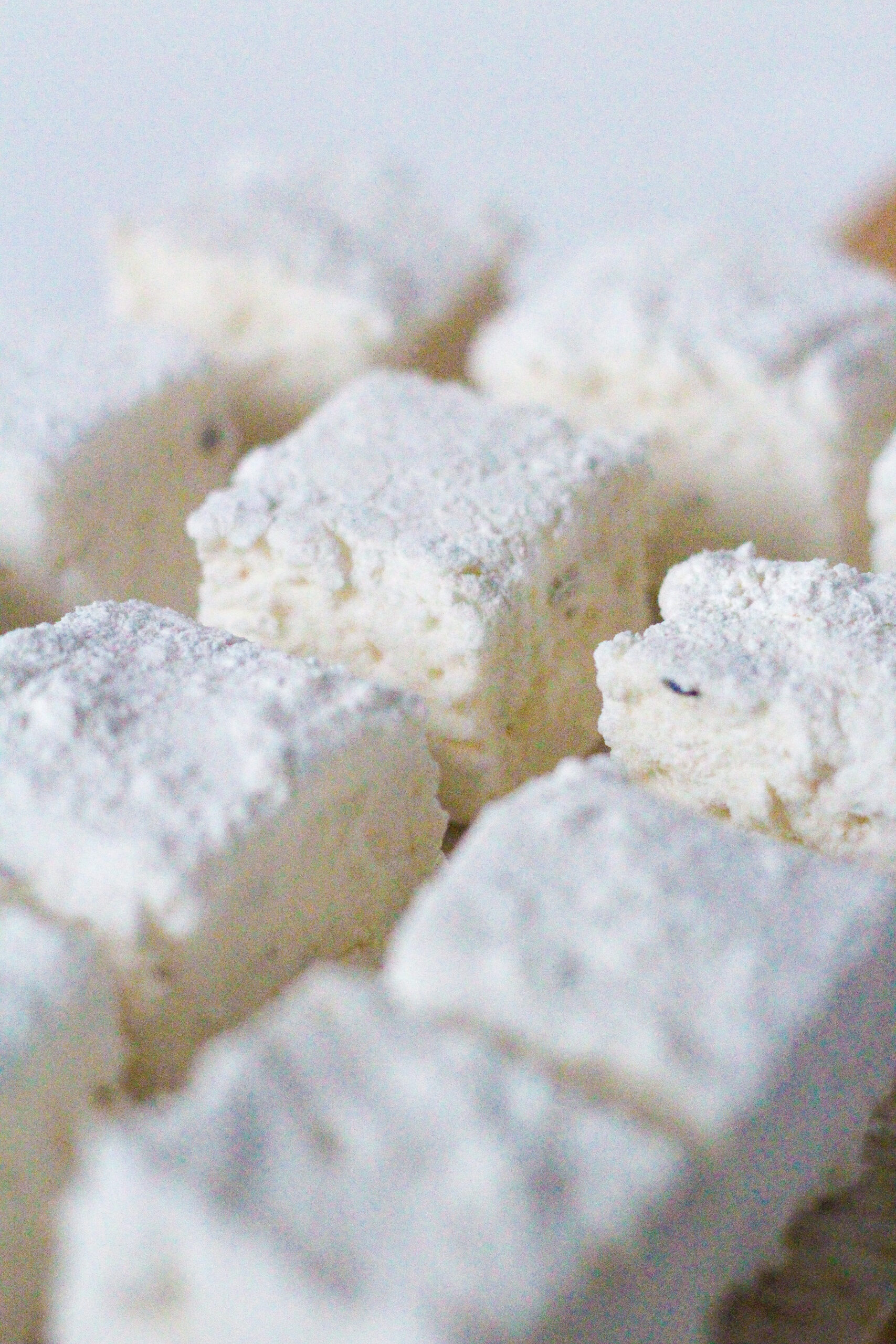 Close up of lemon lavender marshmallows from a 45 degree angle view. One marshmallow in the middle of others is clear and the others are blurred.