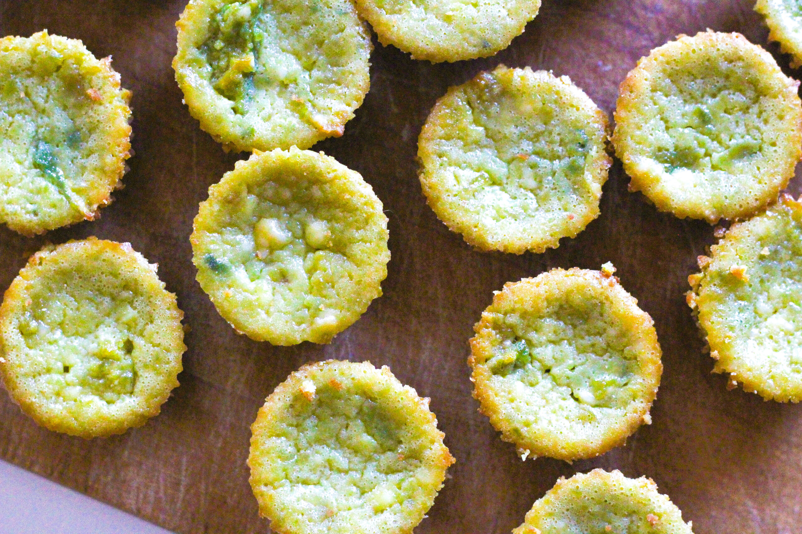 Close up top down view of avocado cheesecakes on a wooden cutting board