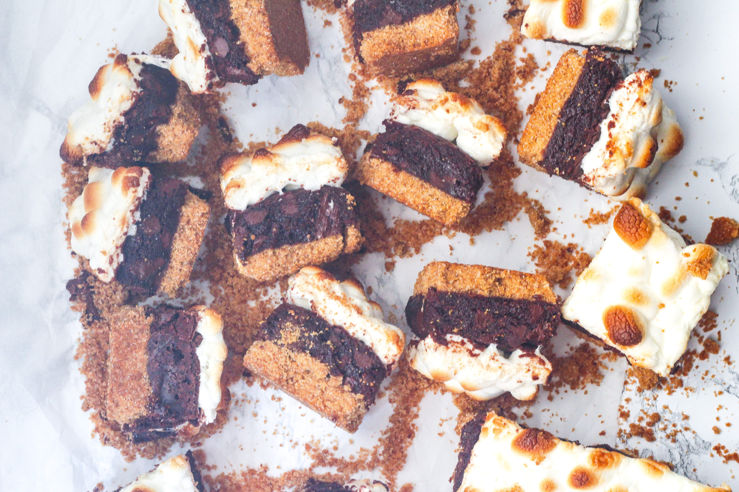 top down view of a bunch of Bailey's s'mores brownies on their sides to see the three layers of graham cracker crust, brownie center, and toasted marshmallow topping