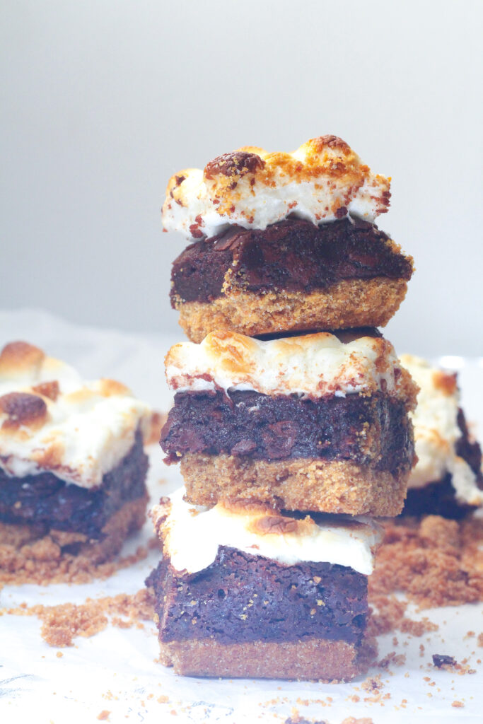Side view of a stack of three Bailey's s'mores brownies with some brownies around the stack