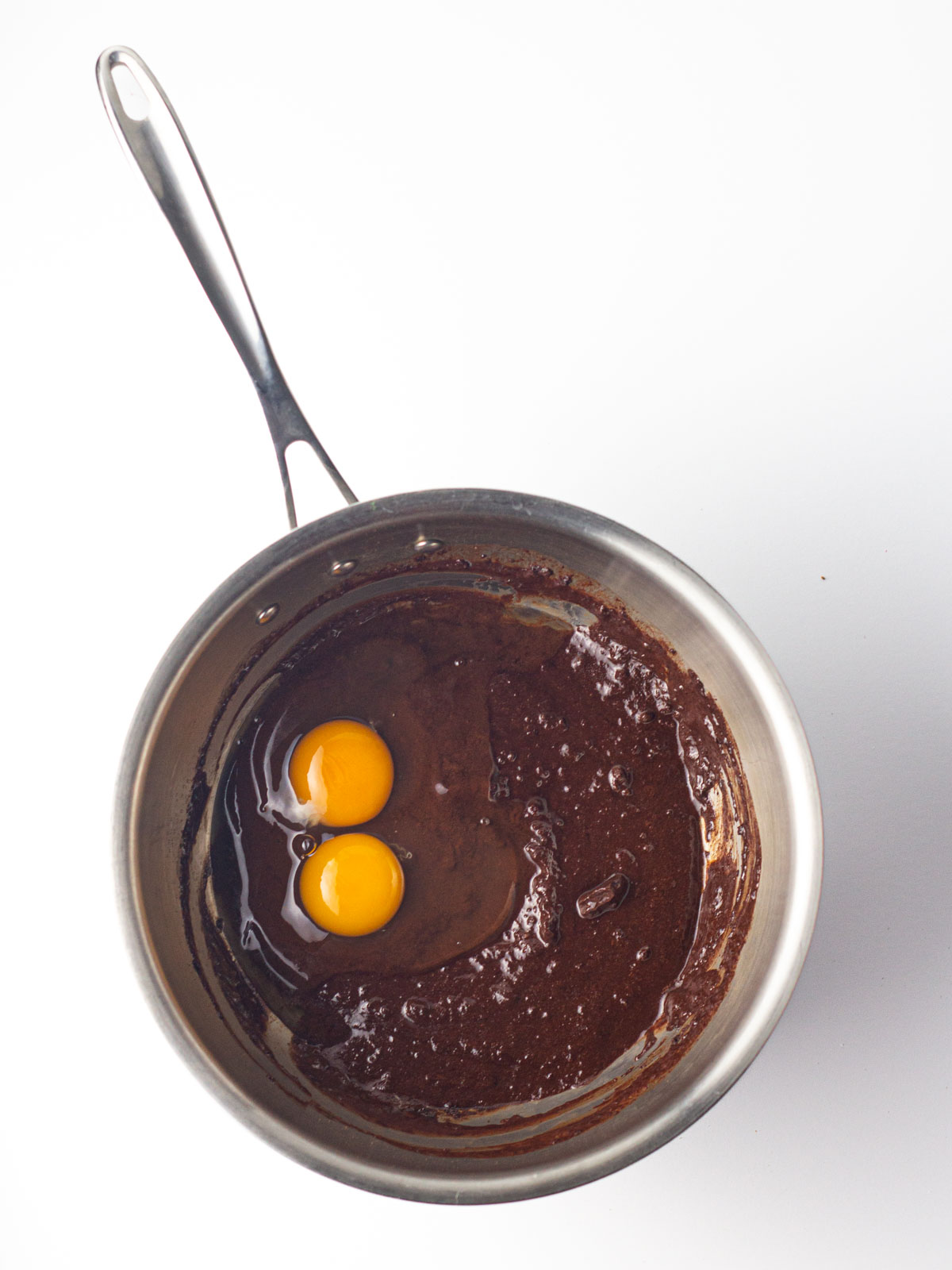 Eggs added to the peppermint mocha brownie batter in a medium saucepan.
