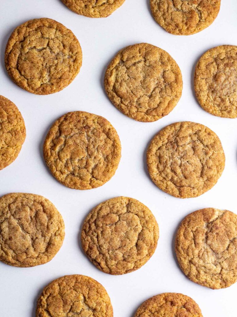 French toast cookies spread out on a white surface.