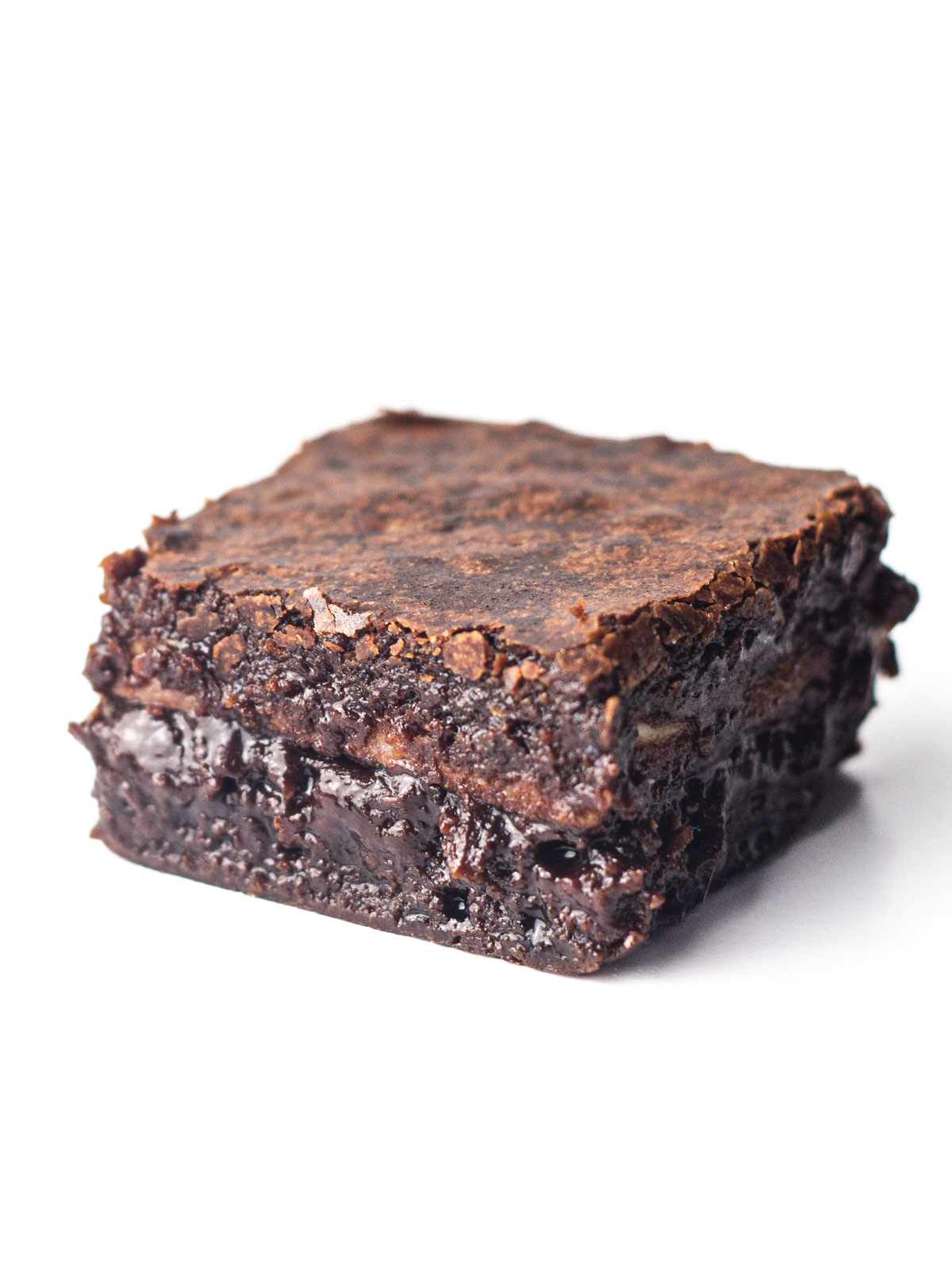 A single peppermint mocha brownie where the layer of peppermint bark is barely visible due to the fudgy chocolate interior of the brownie.