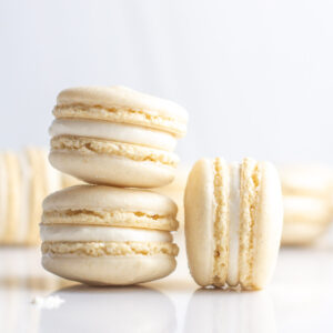 Close up of two oat flour macarons stacked with another on its side next to the stack.