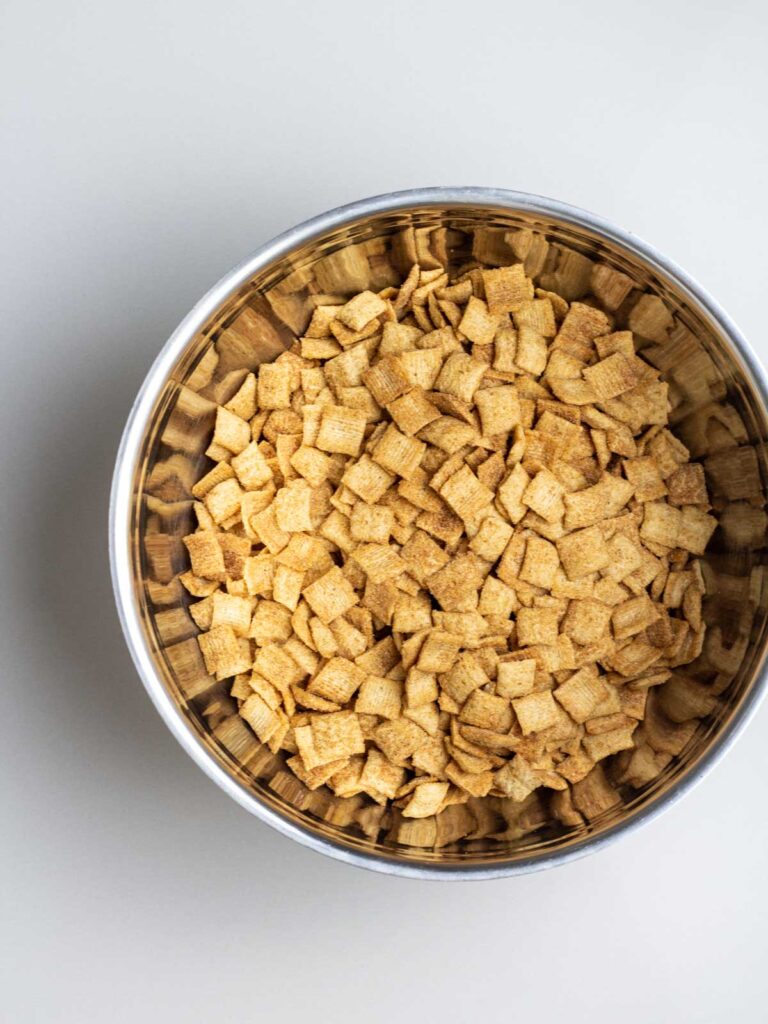 A large mixing bowl filled with cinnamon toast crunch cereal.