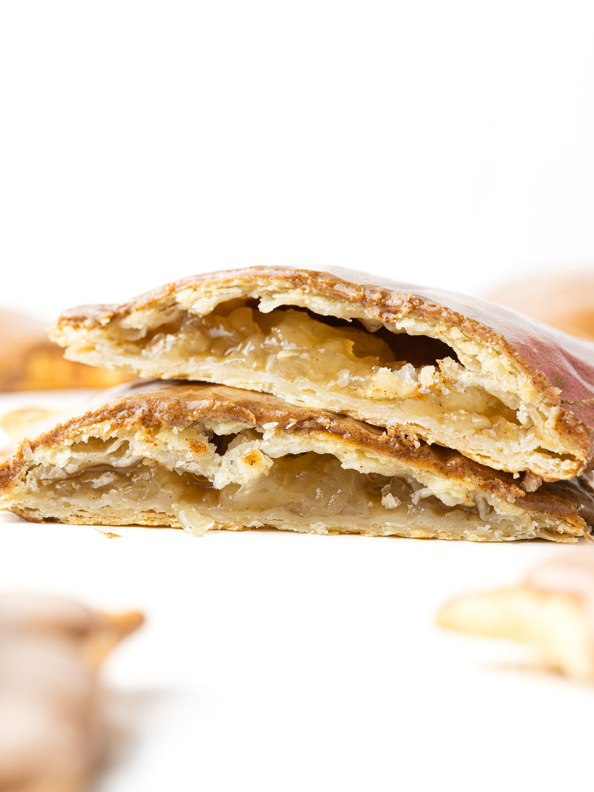 An apple pop tart cut in half with the apple pie filling showing.