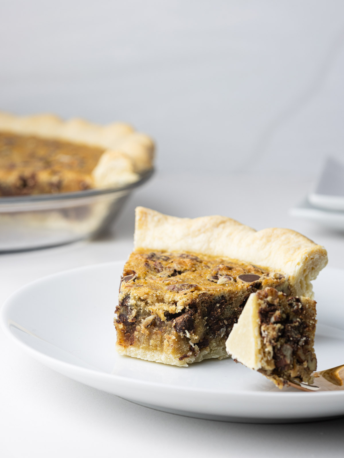 A slice of pie with the tip of the pie slice on a fork.