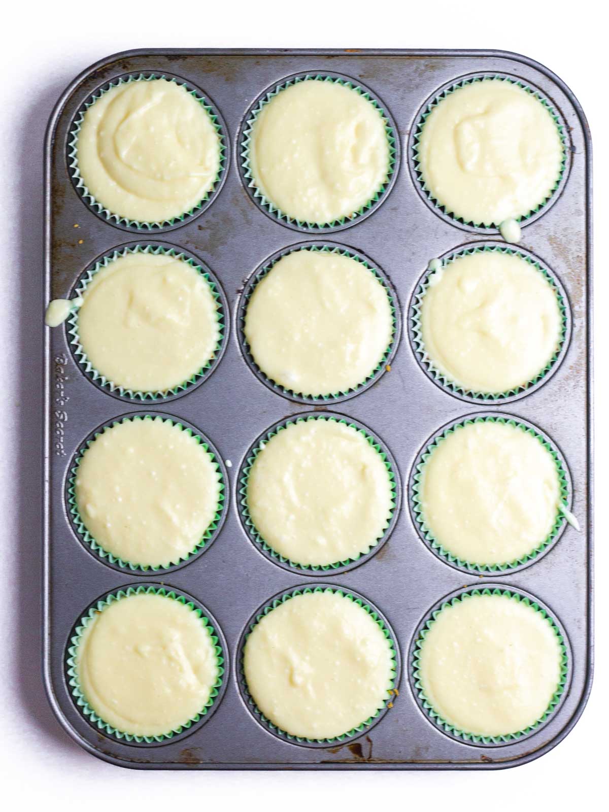 Eggnog cheesecakes in a 12-cup muffin tin, ready to chill.