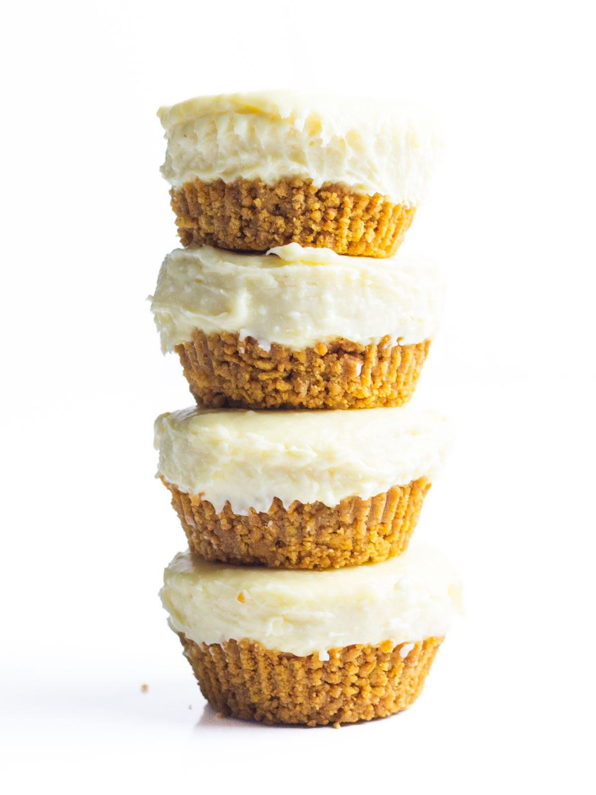 A stack of four mini eggnog cheesecakes with a white background.