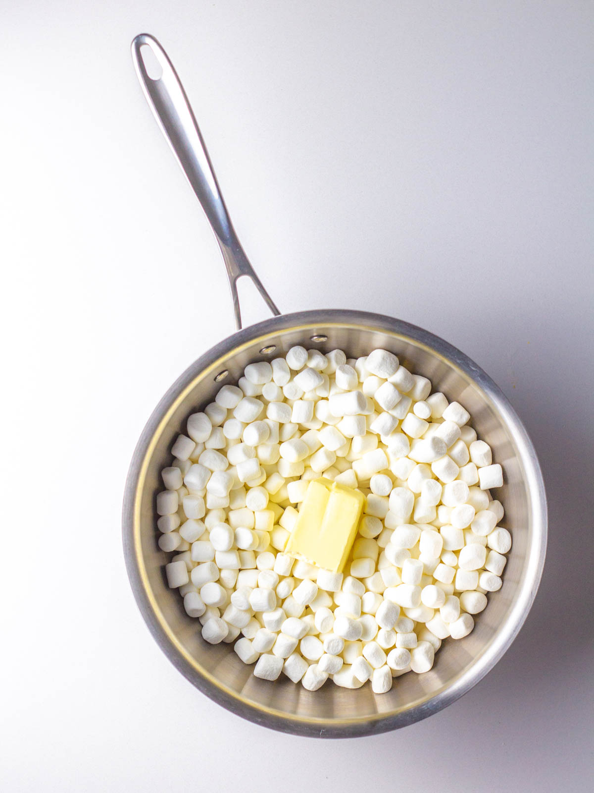Mini marshmallows and butter in a saucepan.