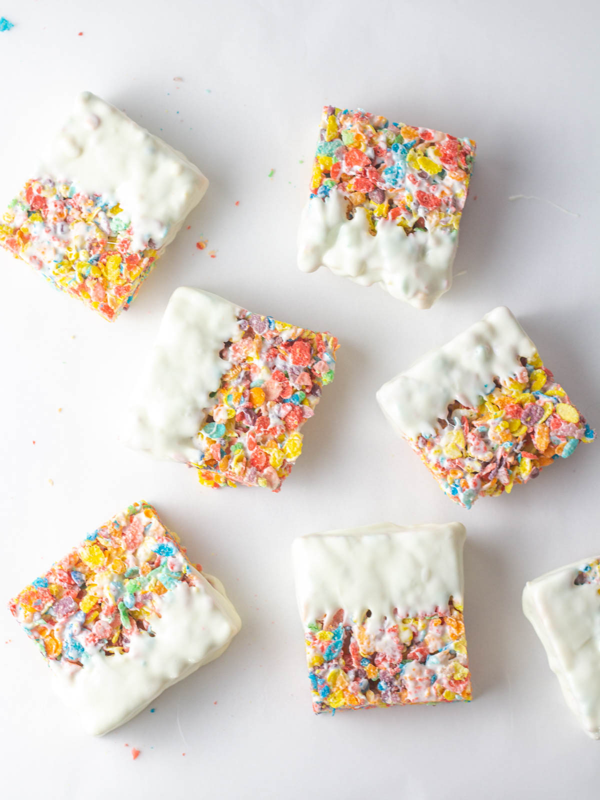 Square Fruity Pebbles Bars with half of each bar dipped into white chocolate.