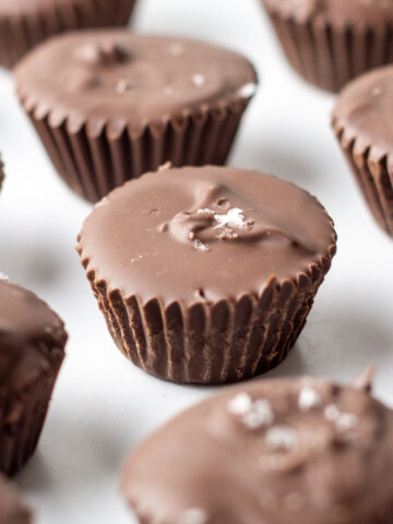 Nutella Cups topped with sea salt spread around on a white surface.