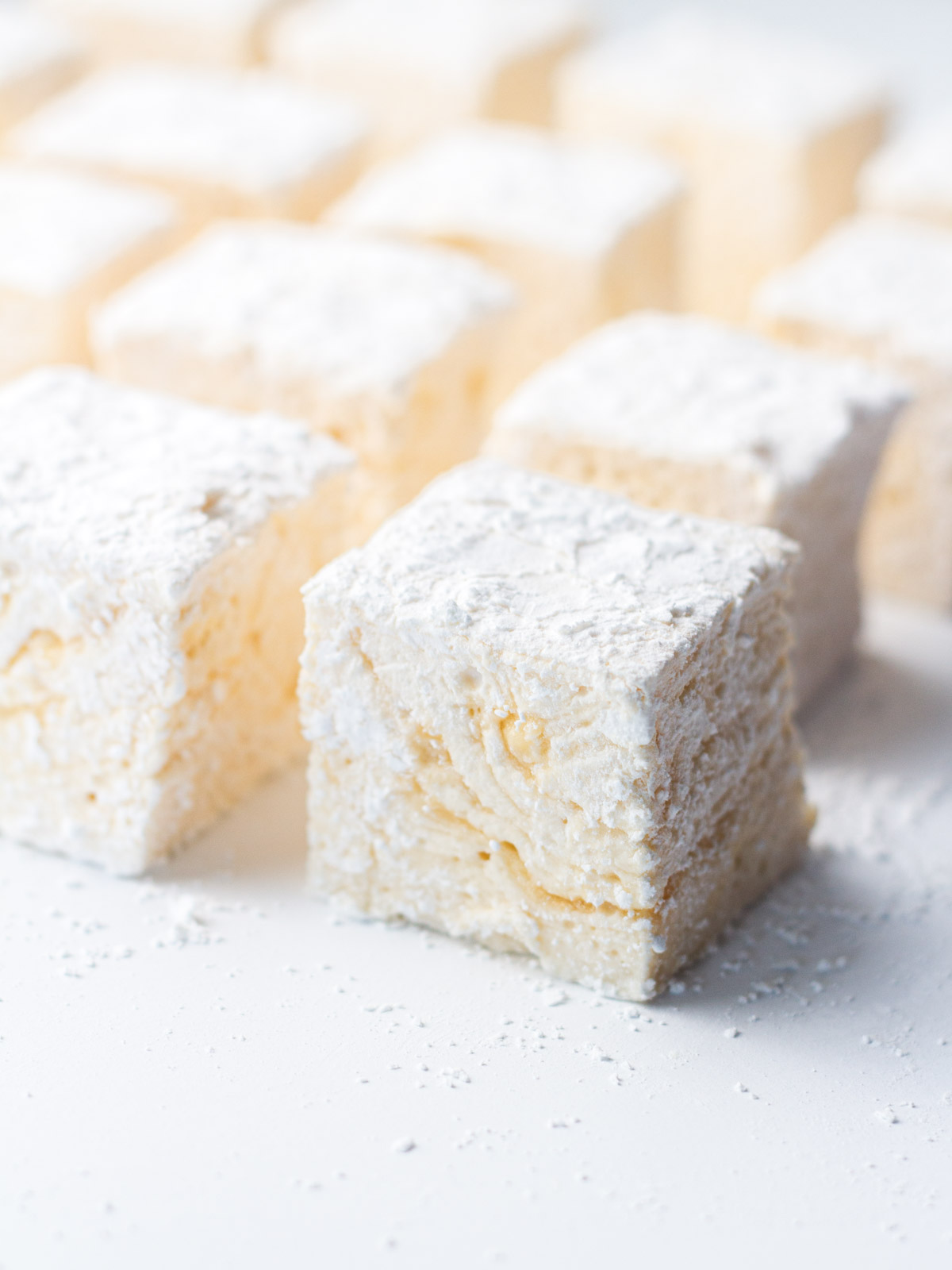An angled view of caramel marshmallows lined up in rows.