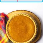 A Pinterest pin of a whole fireball pumpkin pie on a round wooden plank with a red plaid cloth along the left side of the pie.