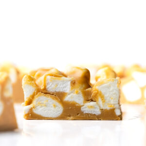 A close-up side view of a peanut butter marshmallow square with more bars surrounding it.