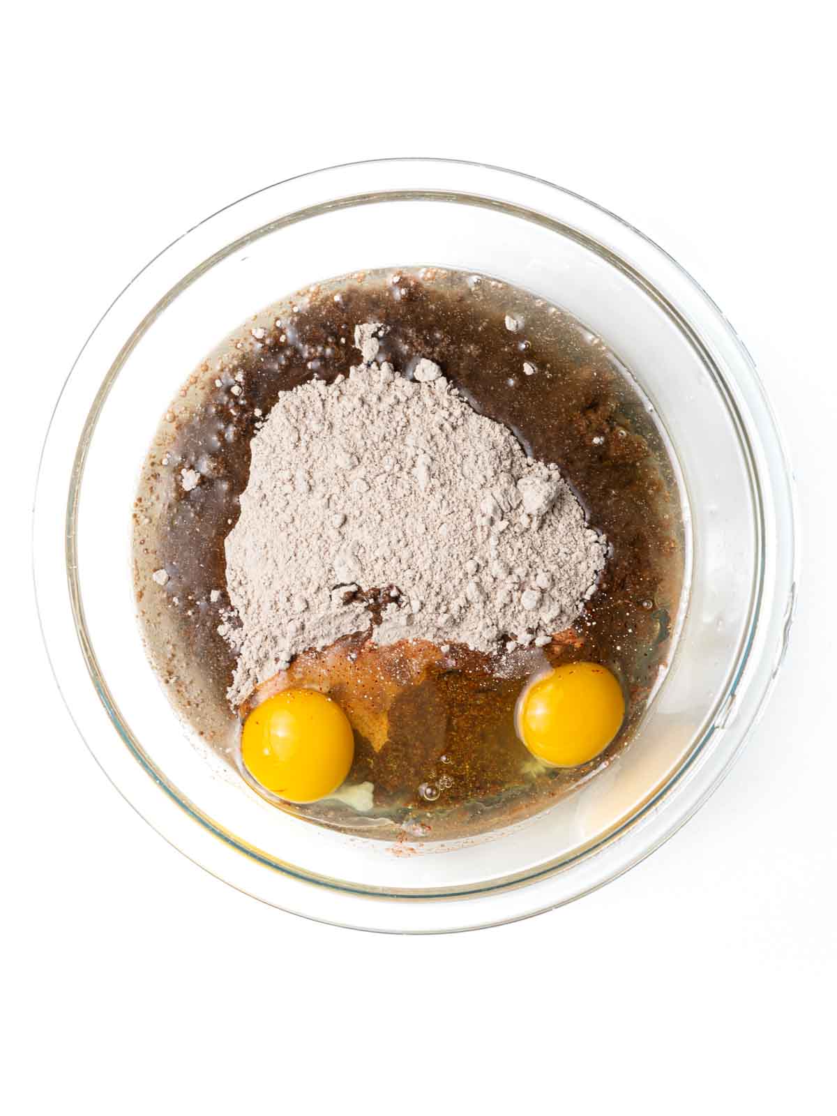 Red Velvet Cake Mix Cookies ingredients in a clear glass mixing bowl.