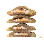 A stack of four halves of Creme Egg Cookies showing the gooey creme egg centers.