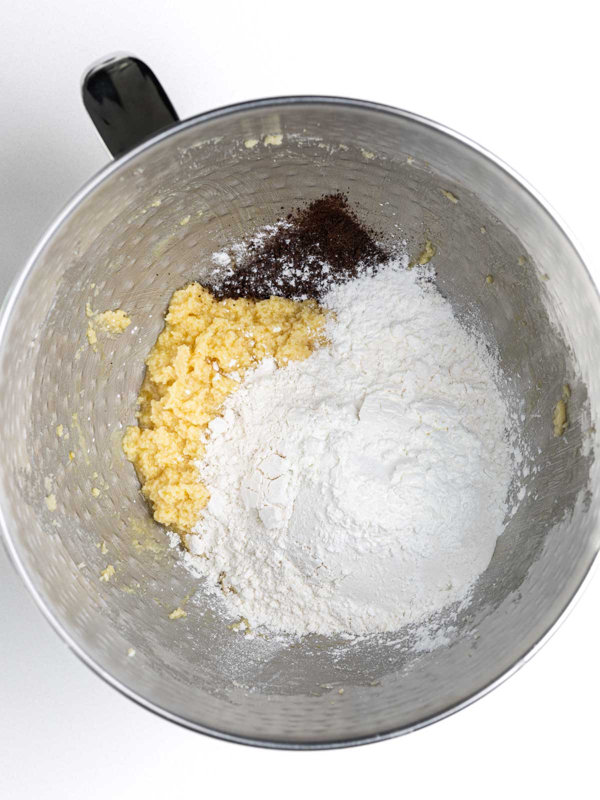 Dry ingredients added to the cookie dough in the mixing bowl.