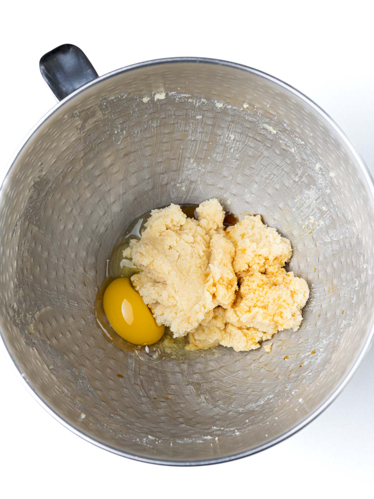 Egg and vanilla added to the creamed butter and sugar in the textured stainless steel mixing bowl.