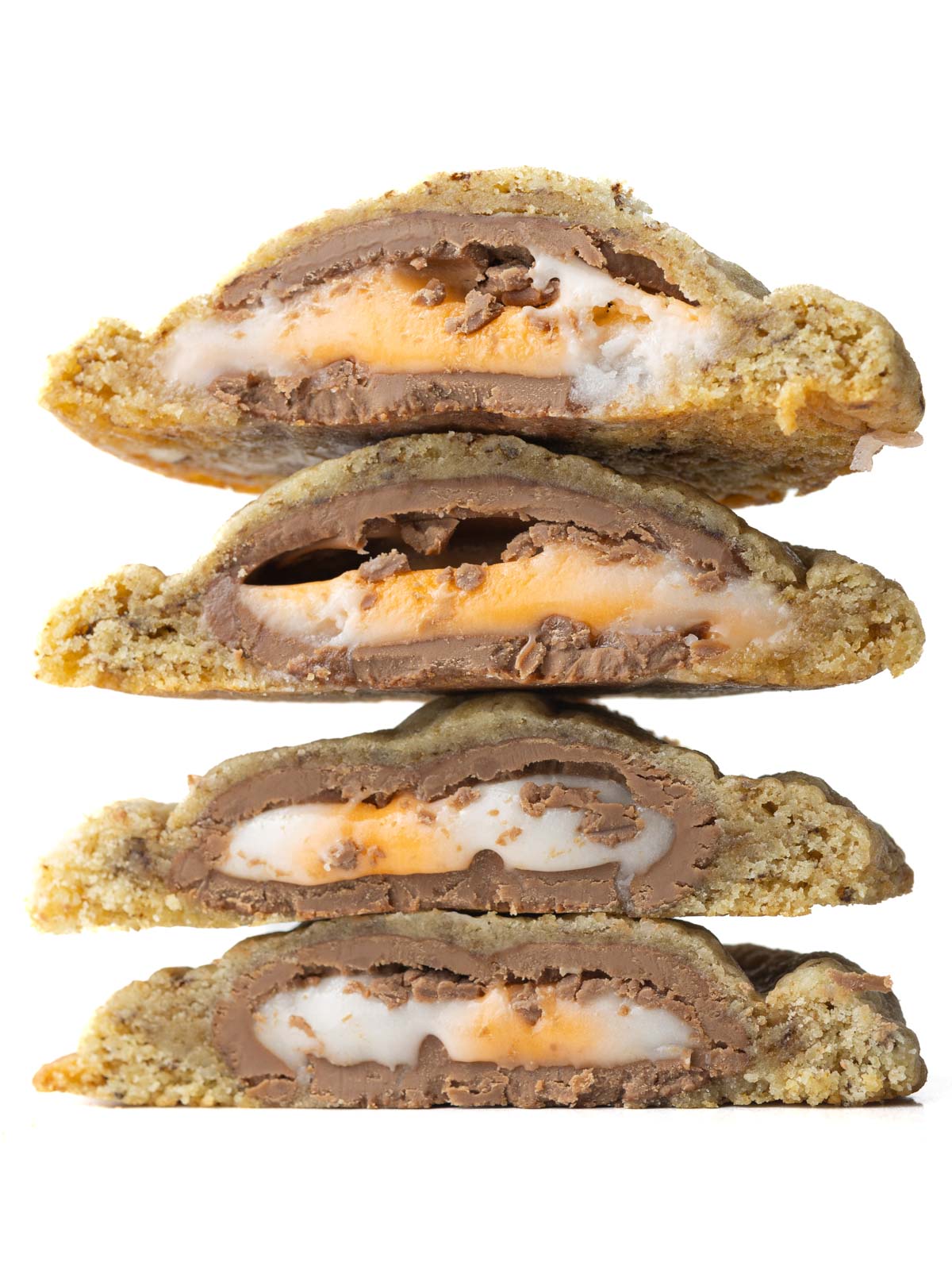 A stack of four halves of Creme Egg Cookies showing the gooey creme egg centers.